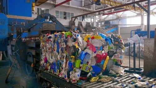Pressing machine making a cube of plastic garbage at waste sorting plant