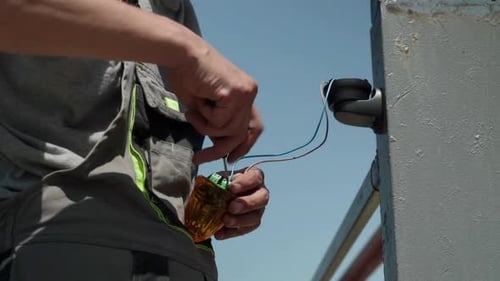 Electrician connects the yellow Signal Lamp for the gate. Warning yellow flash lamp