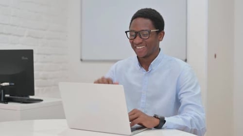 Young Man Video Calling From Desk With Laptop