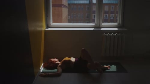 Woman Doing Floor Exercises in Sunlit Room