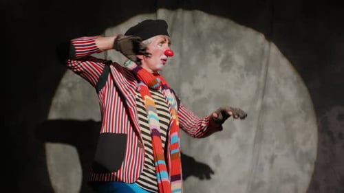 Clown Gesturing with Gloved Hands in Spotlight