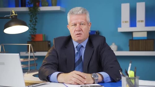 Stressed Businessman Sitting at Desk in Office