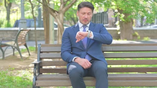Man in Suit Waiting on Park Bench