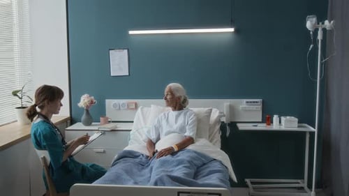 Nurse talking to senior patient in hospital room