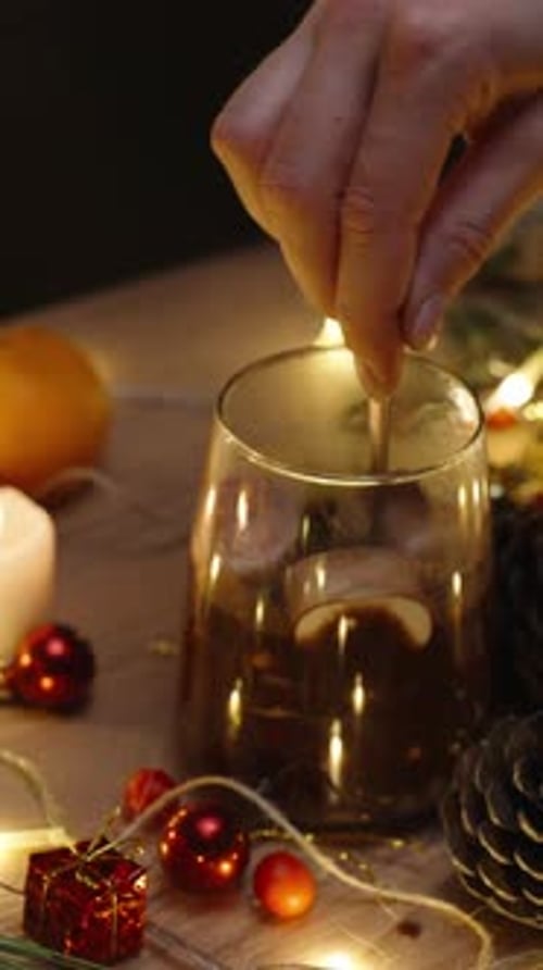 Vertical video. I stir marshmallows in cocoa, hot chocolate. Christmas table with candles and decora
