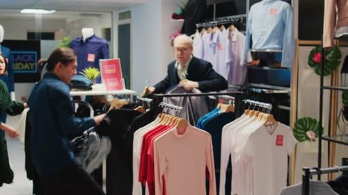 Customers Browsing Clothing Store During Black Friday Sale