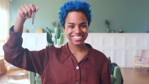 Young Beautiful Happy African American Woman Homeowner Shows Key to New Apartment