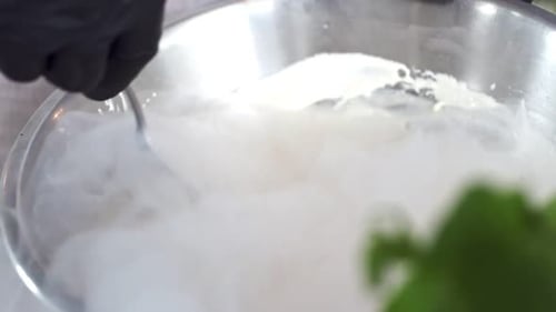 Der Chefkoch kocht natürliches Eis aus Sahnesirup und flüssigem Stickstoff