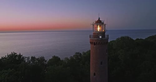 Glühender Leuchtturm nach Sonnenuntergang an der Ostsee in Polen.