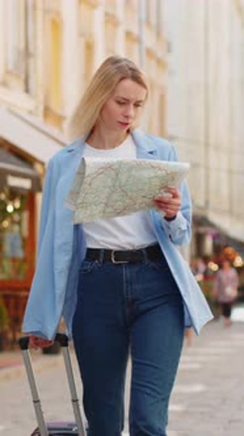 Woman Traveler with Map and Luggage on City Street