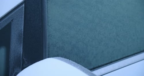 A car covered by frost on a winter morning, close up, slow motion
