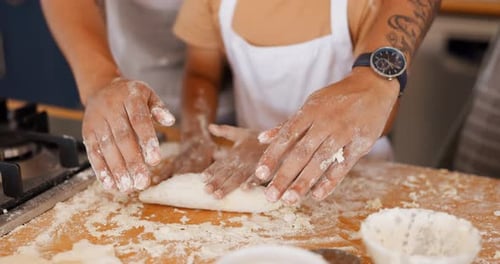 Child and Adult Knead Dough Together in Kitchen