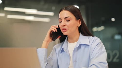 Positive Woman Engaged in Business Phone Call at Office