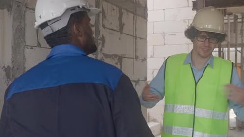 Construction Workers Discuss Project at Building Site