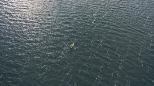 Aerial View of Lonely Motorboat on Gray Water Surface with Waves with White Foam