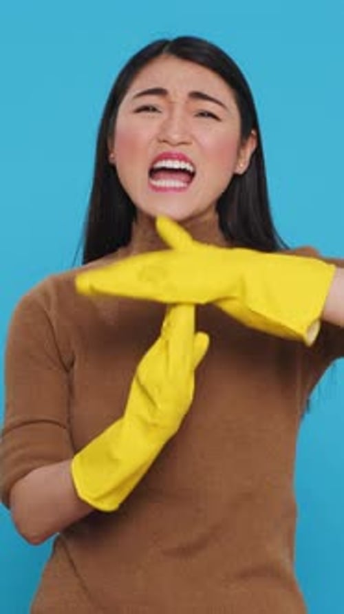 Vertical Video Asian Homemaker Doing Time Out Gesture During House Cleaning in Studio