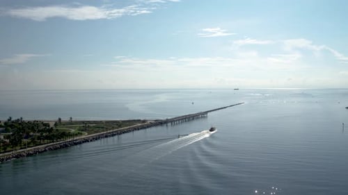 Boat leaves the sunny Miami harbor on a beautiful summer day with blue ocean