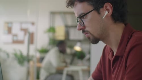 Man Typing on Laptop at Work in Office