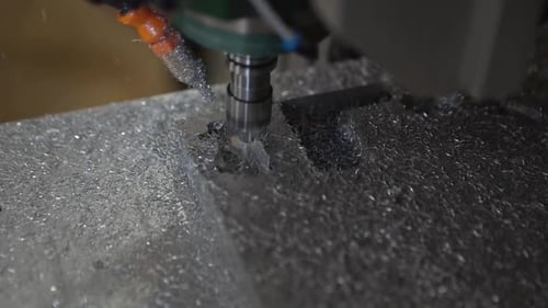 Detailgetreu zeigt eine Nahaufnahme eine CNC-Maschine, die in ein Aluminiumblech schneidet, und enthüllt die