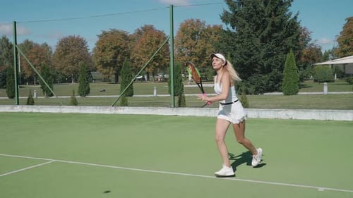 Young Woman Professional Tennis Player Hits the Ball with a Racket Practice Game on the Tennis Court