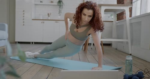 Woman Doing Side Plank At Home On Yoga Mat