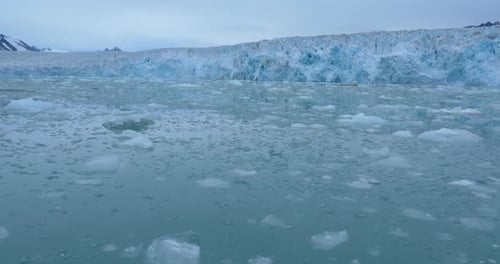 Naviguer près d'un grand iceberg bleu et des montagnes de l'Arctique