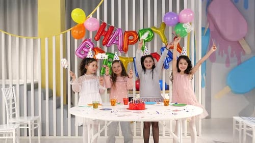 Funny Kids with Paper Birthday Party Accessories Having Fun at a Party