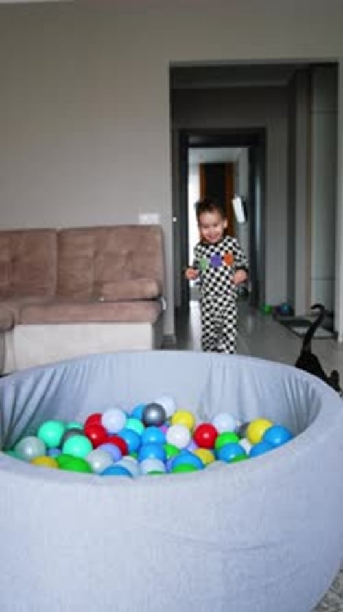 A dry pool with colorful balls is in the living room.