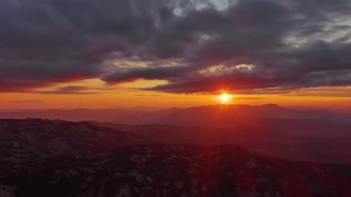 Orange Sunset Over Mountain with Dramatic Clouds