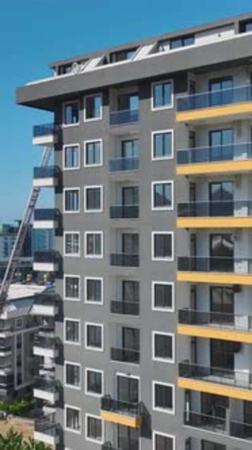 Vertical Video Aerial View of Workers Handling Metal Installing Facades and Cutting Stone Materials