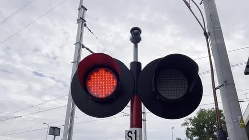 Red Traffic Light on a Pole with Sky Clouds Tree and Auto Parts