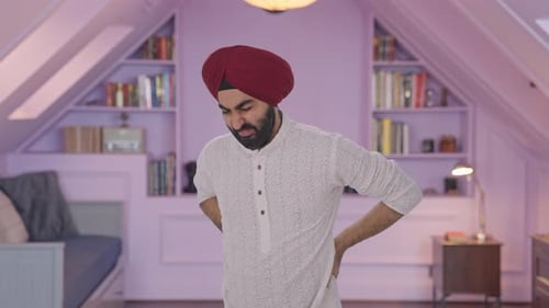 Man Stretches and Grimaces in Pain