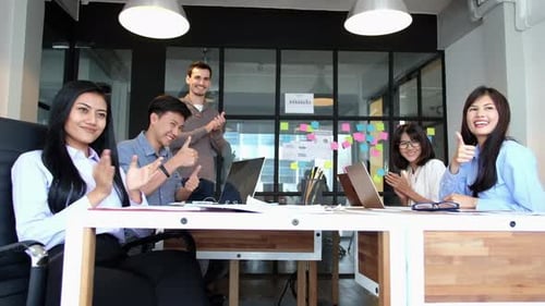 Smiling Team Applauding Success in Bright Office