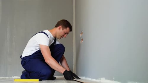 Man Installing Laminate Flooring in New Home