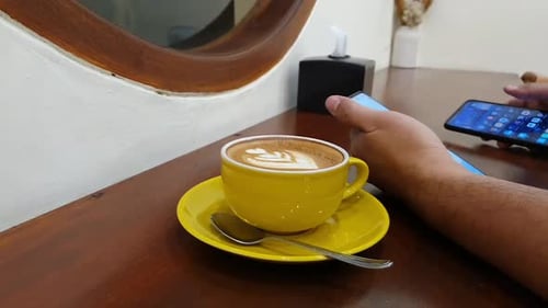 Man using smart phones and drinking coffee in Cafe