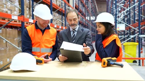 Warehouse workers examining inventory checklist