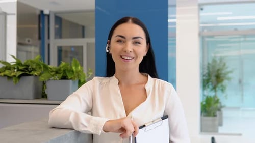 Smiling Young Adult Woman at Reception Desk