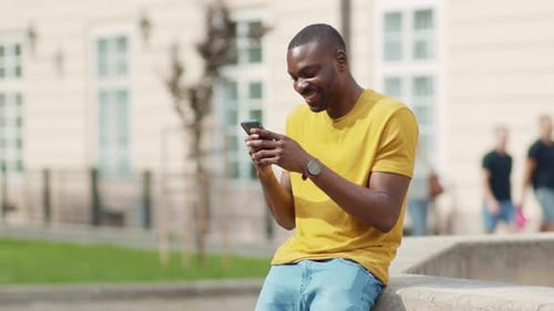 Close Up Stylish African American Young Attractive Man Using Phone Stand on Street Smile Sunlight