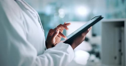 Woman in Lab Coat Using Digital Tablet