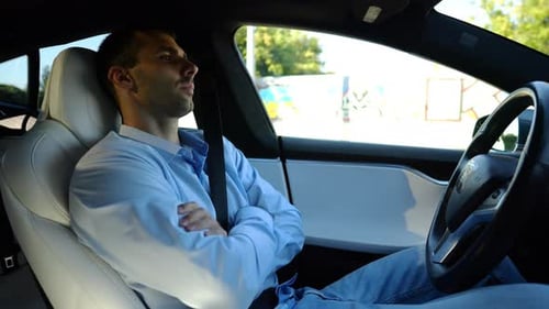 Male Businessperson Experience to Ride an Autonomous Self Driving Electric Car at Urban Road