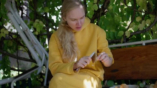 A Woman Cleaning Porcini Mushrooms in the Garden with a Knife