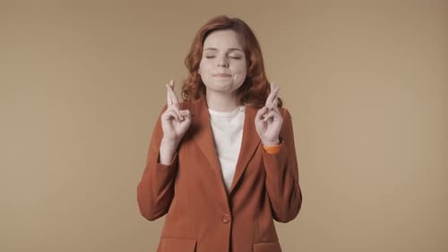 Medium Isolated Video of a Joyful Young Woman Crossing Her Fingers Making a Wish in Her Mind with