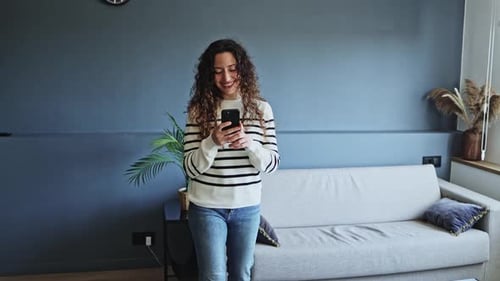 Woman Using Smartphone in Modern Home Setting