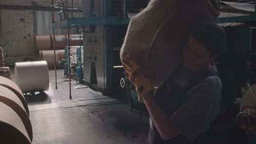 Female Factory Worker Carrying Heavy Bag on Shoulder