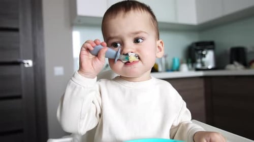 Cute Baby Eating Food with a Spoon