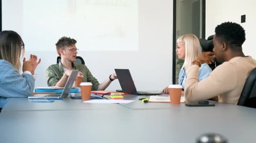 Diverse group of young business people working on new project together in office.