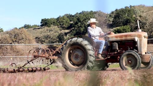Vintage Tractor Driving Across a Rural Field