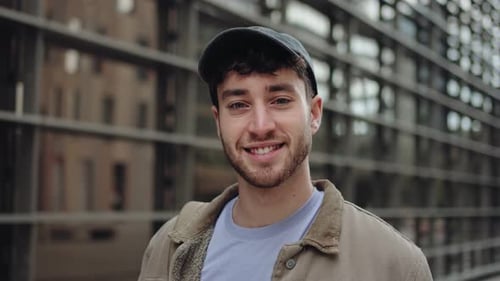 Portrait Young Man with Cap Standing in the City Looking to the Camera with Confident Expression