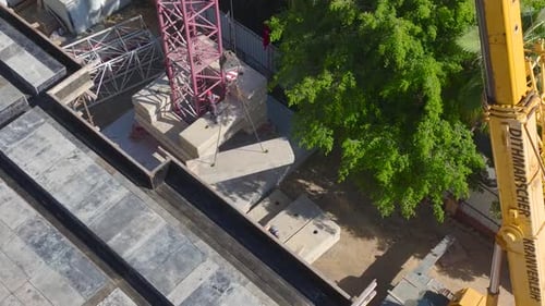 Aerial View Operators Lift and Position a Crane Onsite with Engineers Supervising the Process for