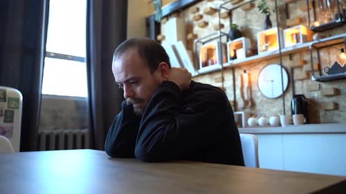 Man Sitting Alone Lost in Thought at Table